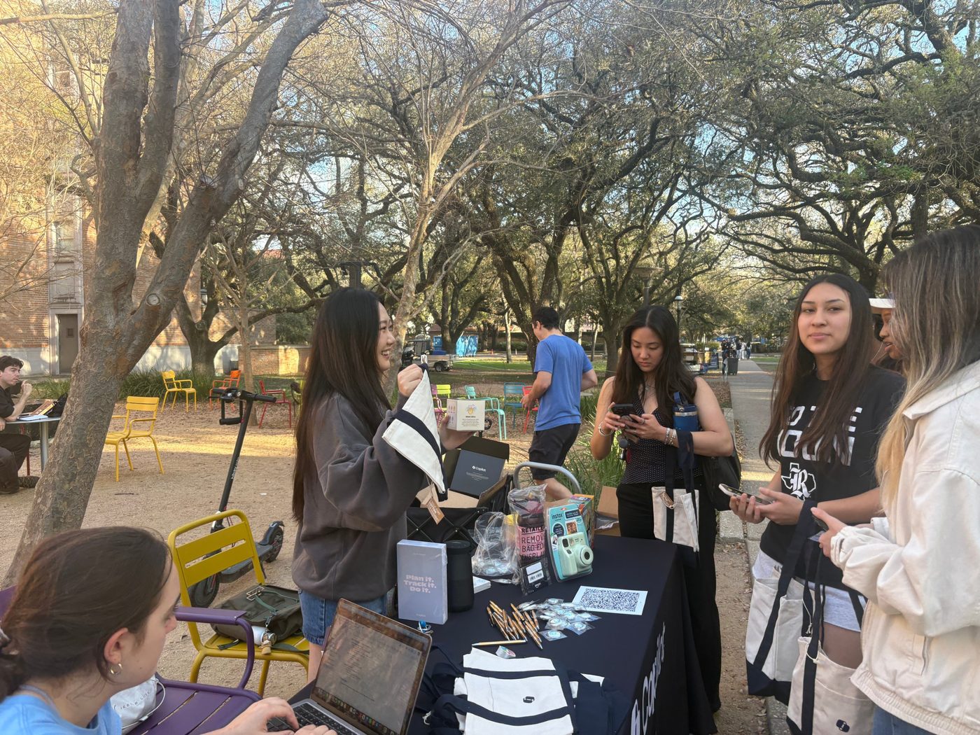 Danielle showing Copilot swag to students at a campus table