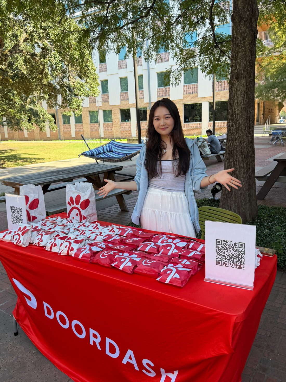 Danielle hosting a DoorDash table with free Chick-fil-A and sign-up QR codes